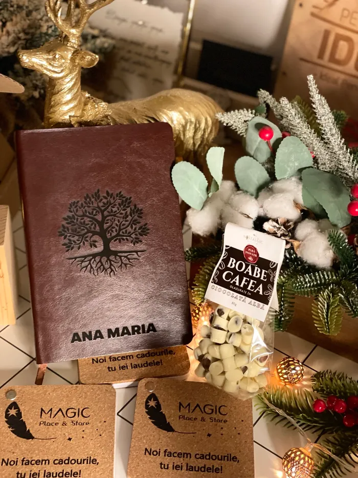 Agendă maro cu numele Ana Maria și motiv de copac, alături de accesorii și cafea